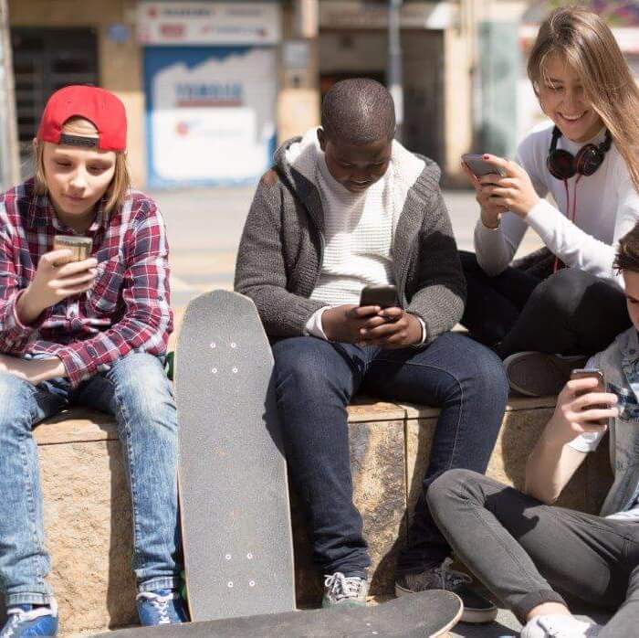 Jongeren buiten op telefoon